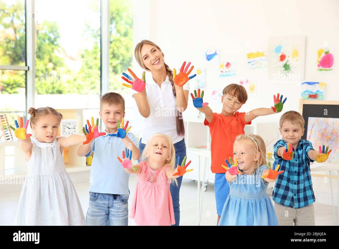 Children and teacher with hands in paint at art lesson Stock Photo - Alamy