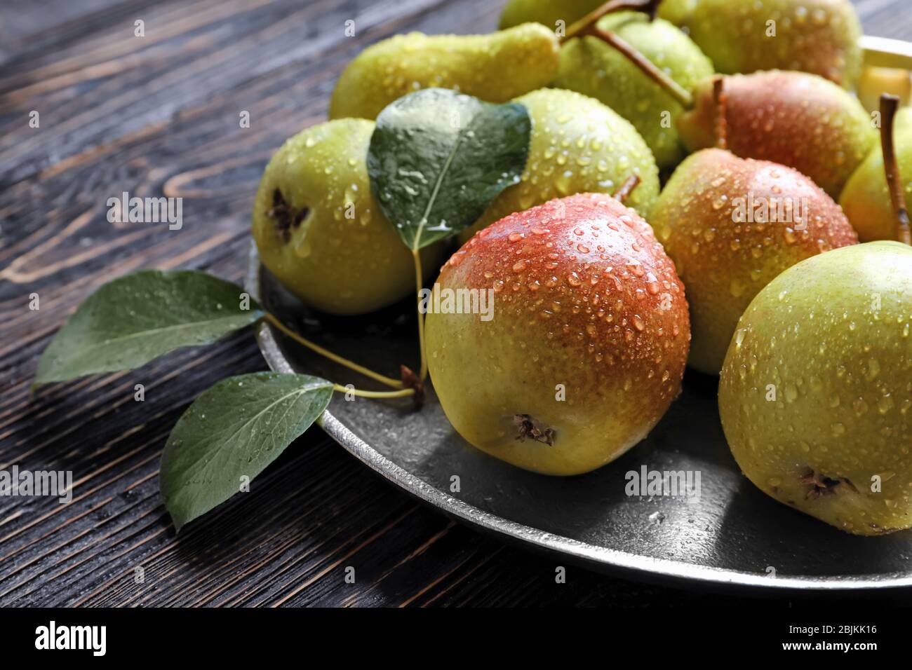 Metal plate with delicious ripe pears on table Stock Photo