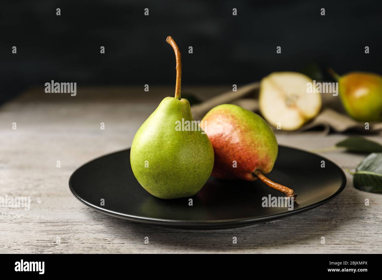 Ripe pears on black plate Stock Photo