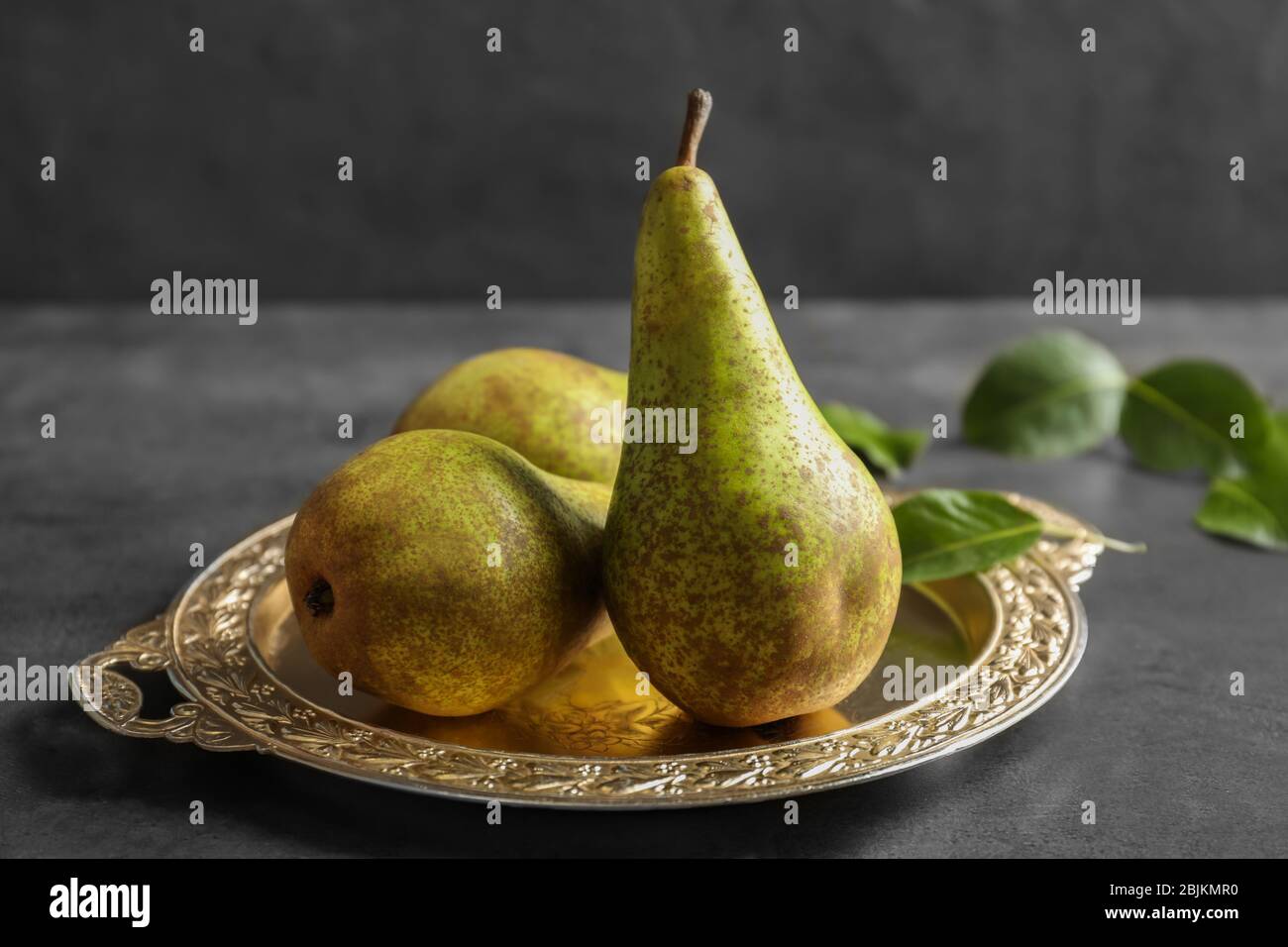 Ripe pears on ornate metal plate Stock Photo