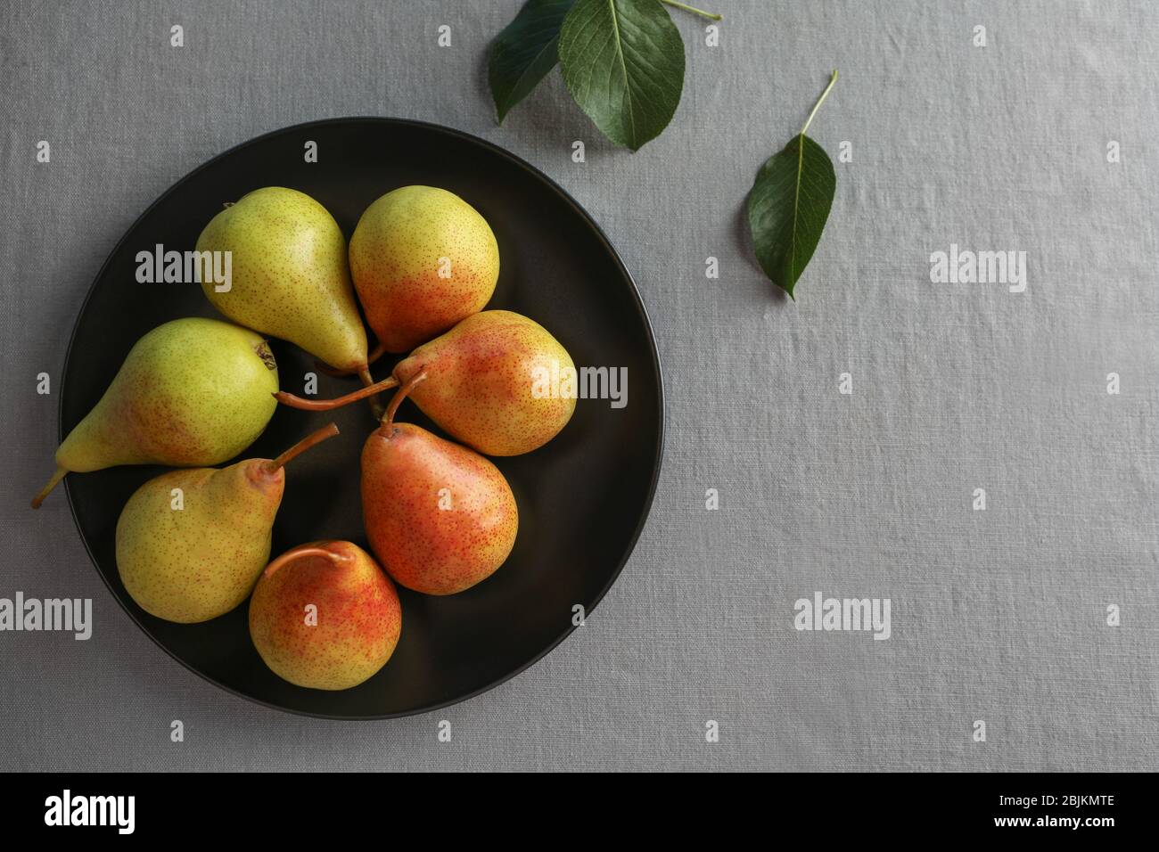 Ripe pears on black plate Stock Photo