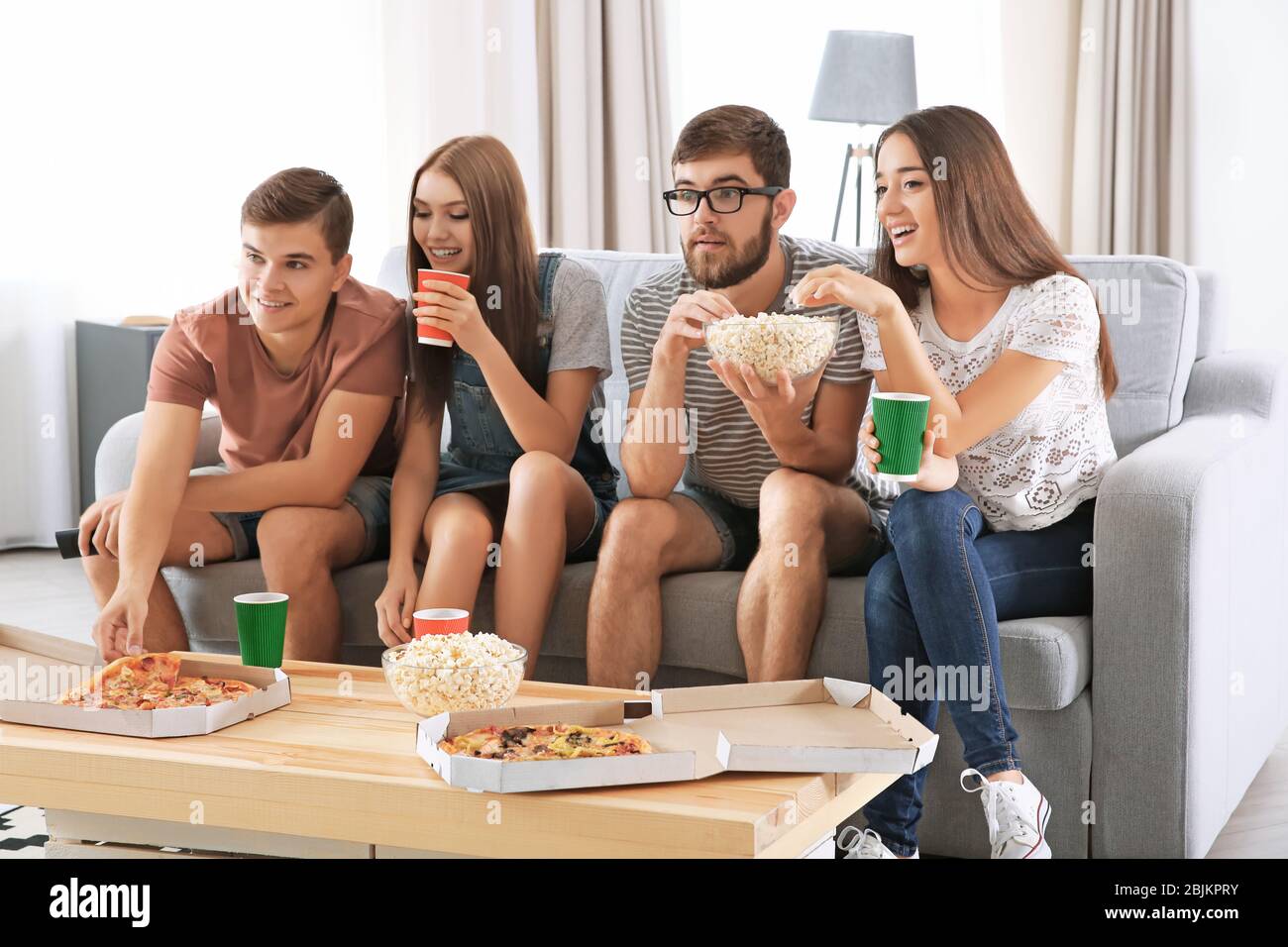 Friends watching TV at home Stock Photo