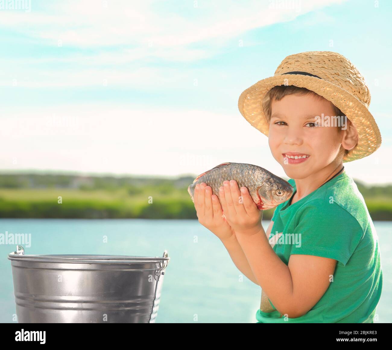 Cute little fisher with catch on summer day Stock Photo - Alamy