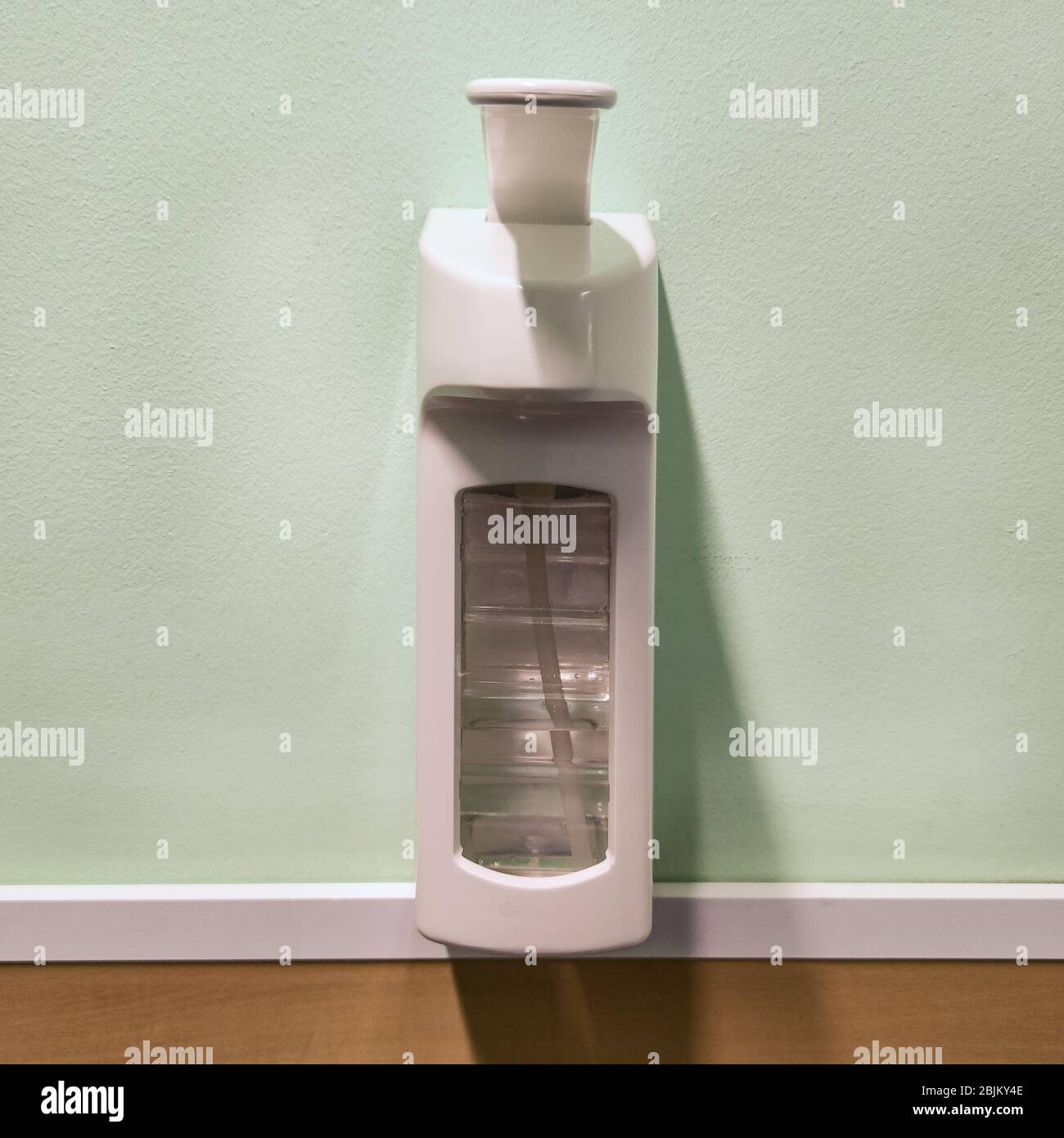 Hand sanitizer in dispenser without any brand logos on the wall. Stock Photo