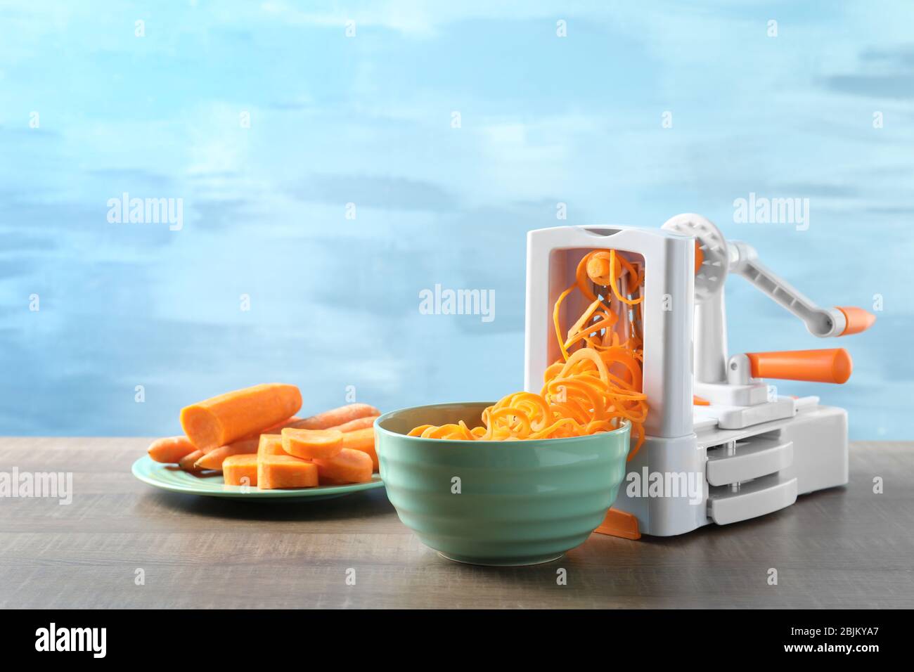 Spiral vegetable slicer with carrot spaghetti on table Stock Photo