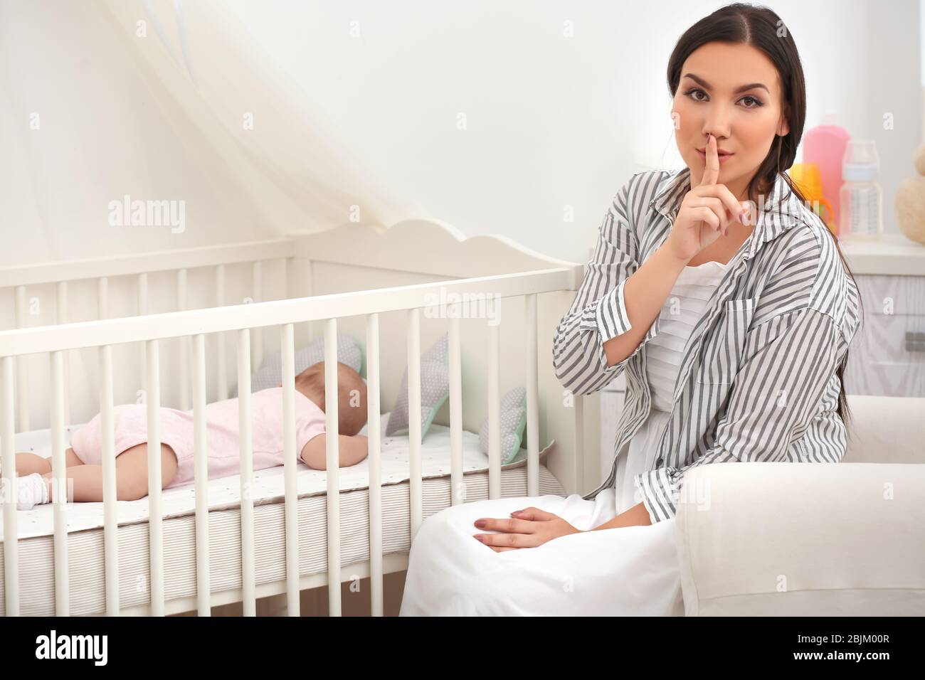 Mother sleeping in clearance crib with baby