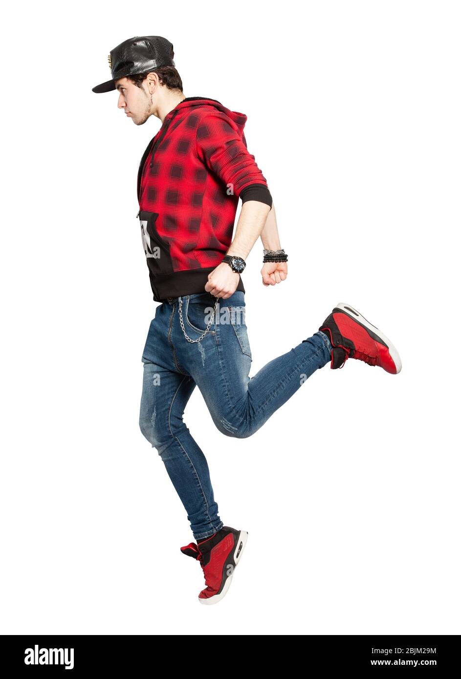 Young urban street dancer action. On white background. Modern dance, hip hop. He have only one foot on the floor, seen in profile. He wears a hat with Stock Photo