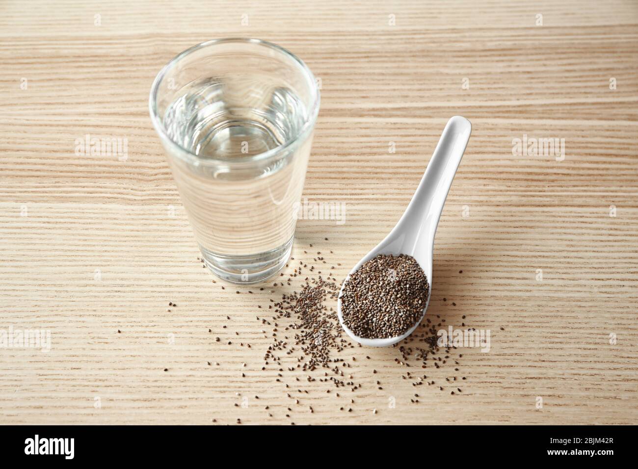 Spoon With Chia Seeds And Glass Of Water On Wooden Background Stock Photo Alamy