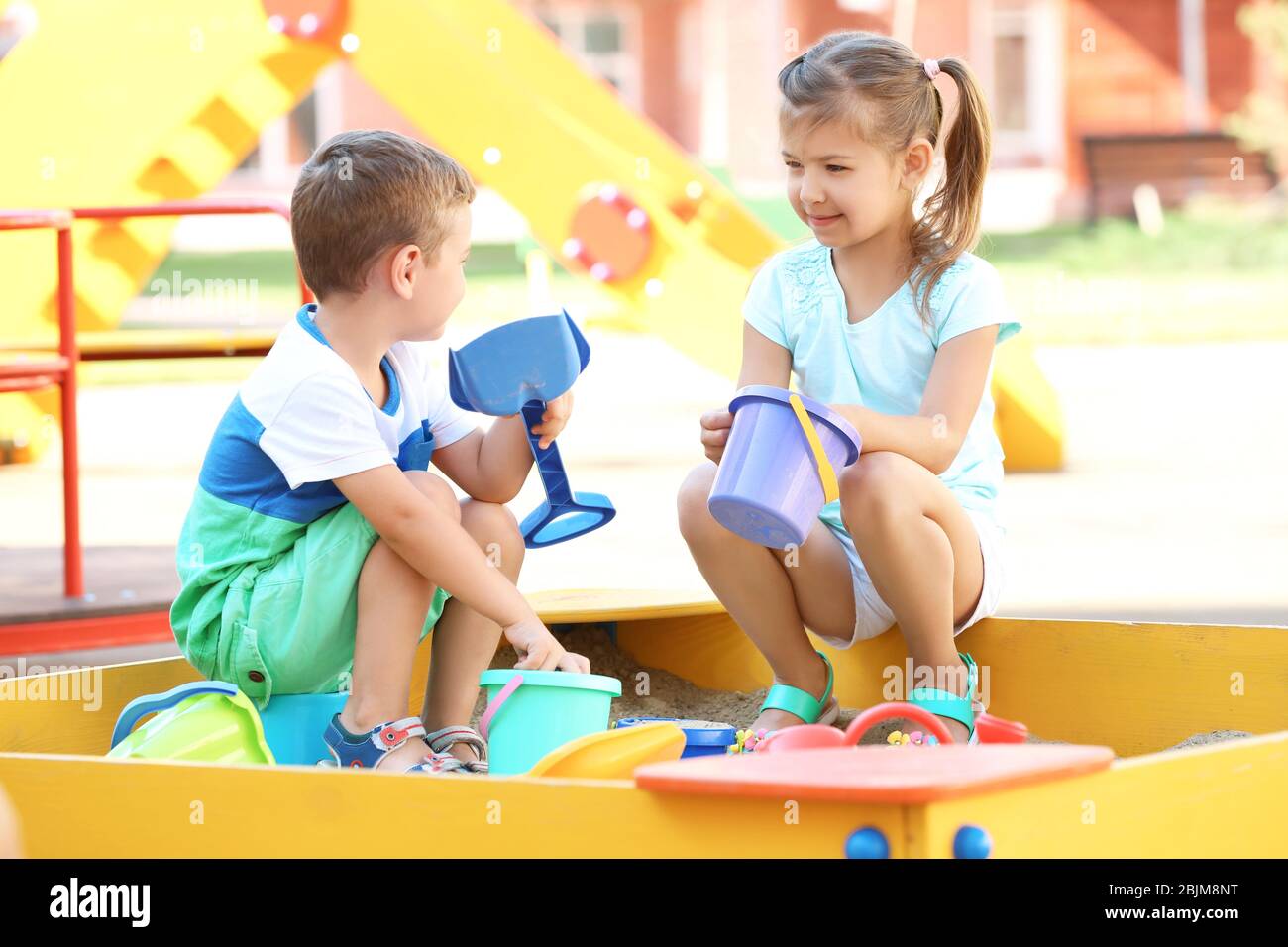 Little children playing with toys in sand box outdoors Stock Photo - Alamy