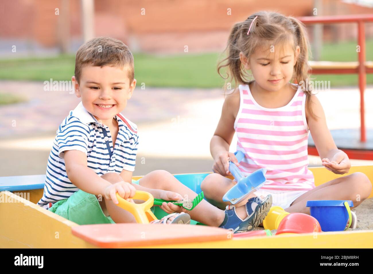 Little children playing with toys in sand box outdoors Stock Photo - Alamy