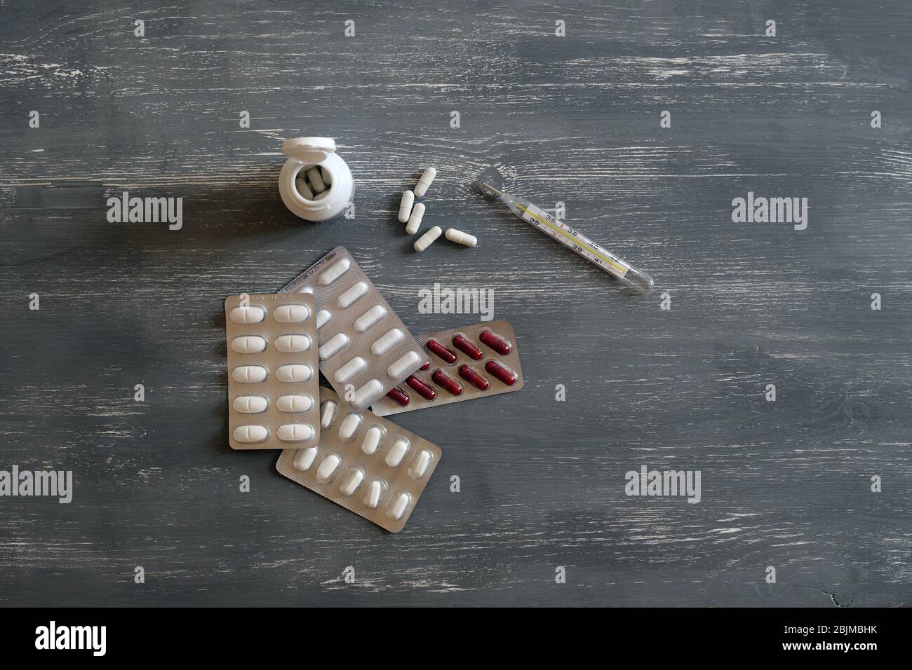 Medication and thermometer to cure illness Stock Photo