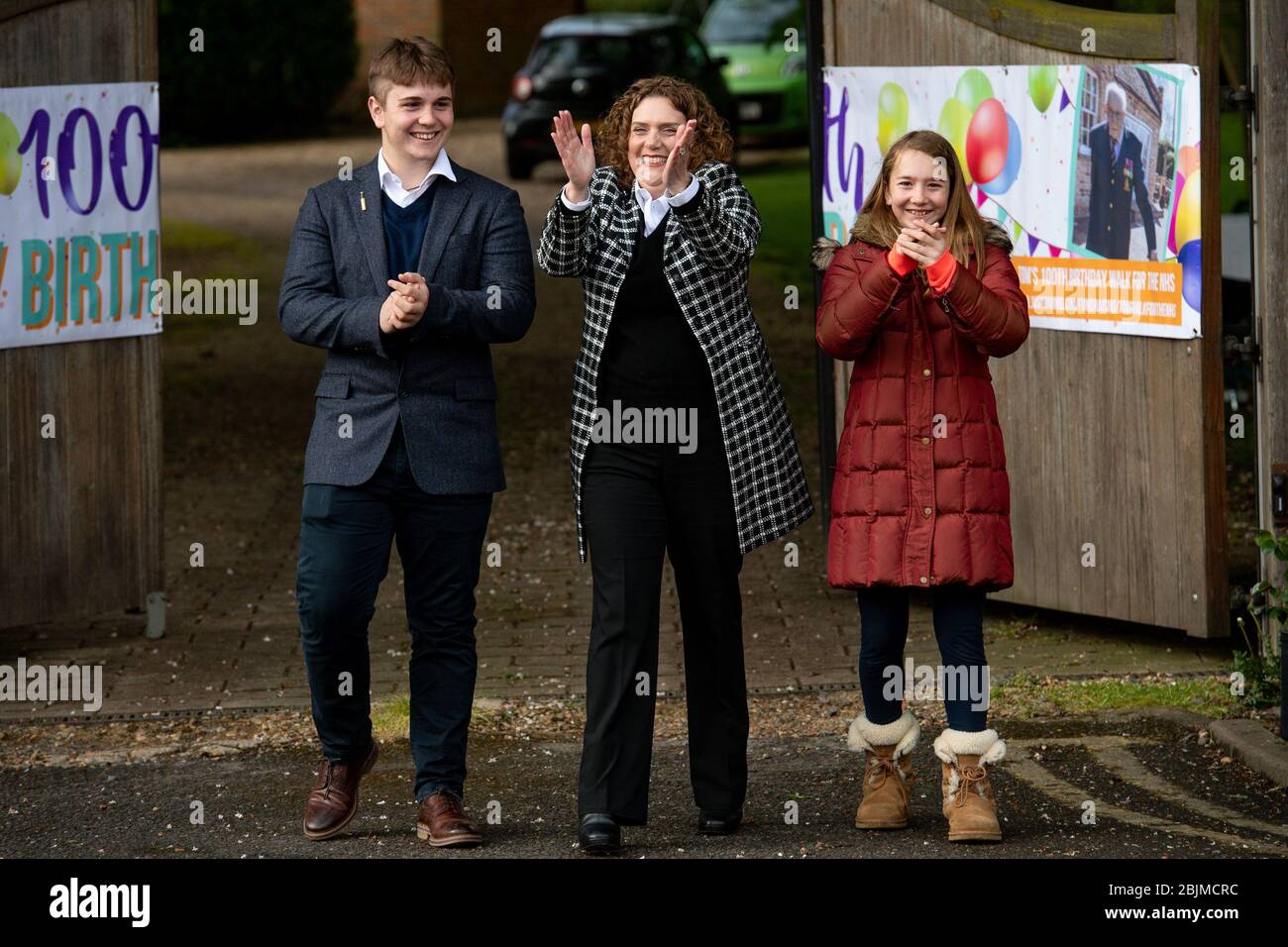 Hannah Ingram-Moore (centre) the daughter of Second World War veteran Captain Tom Moore and his grandchildren Benjie and Georgia Ingram-Moore greet people outside his home in Bedford following a Battle of Britain Memorial Flight flypast of a Spitfire and a Hurricane as he celebrates his 100th birthday. Stock Photo