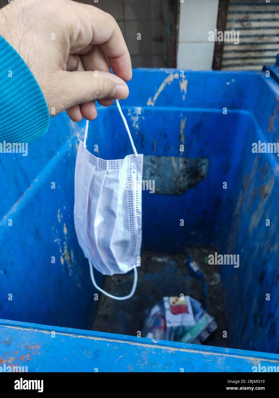 Throwing used face mask to bin or trash. Coronavirus or COVID19