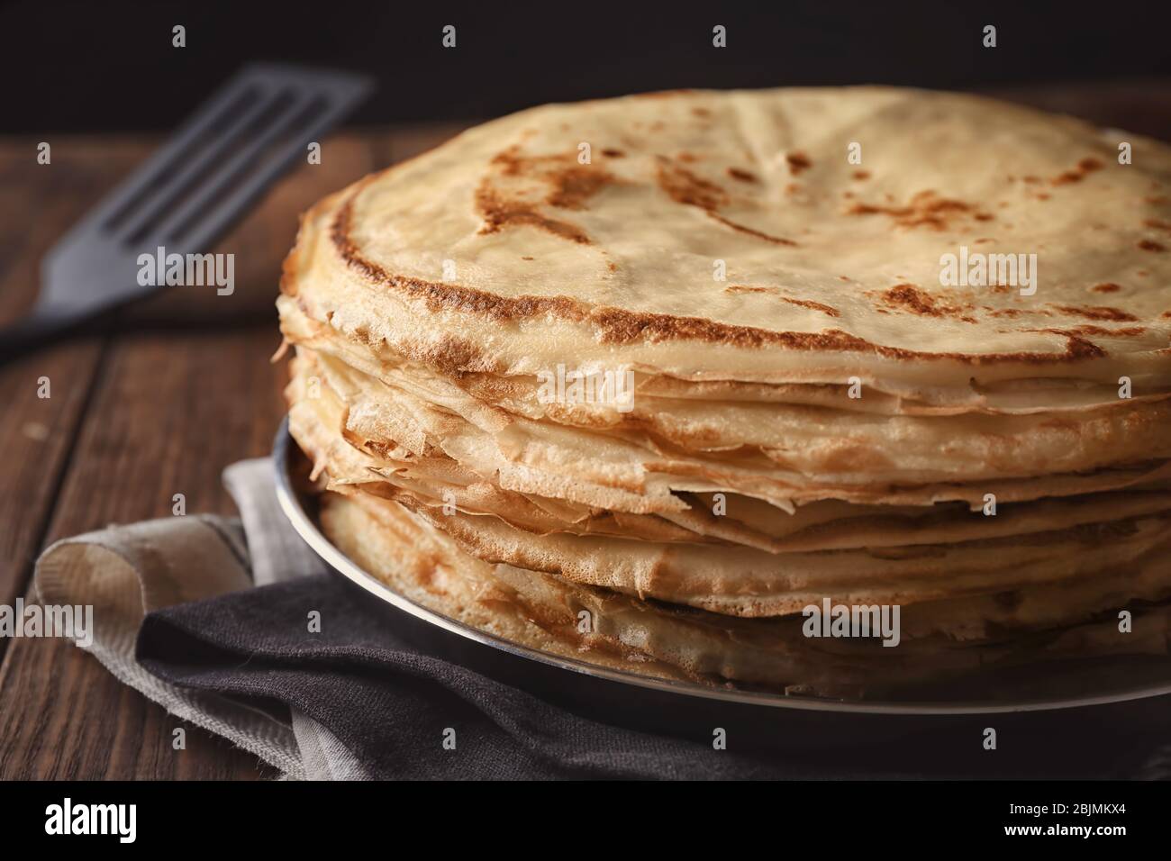 Frying pan with stack of delicious thin pancakes, closeup Stock Photo ...