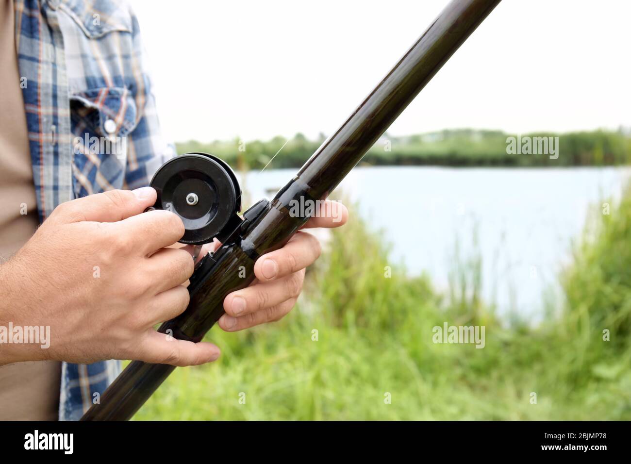 With The Rod Fisherman with rod on riverside, closeup Stock Photo - Alamy