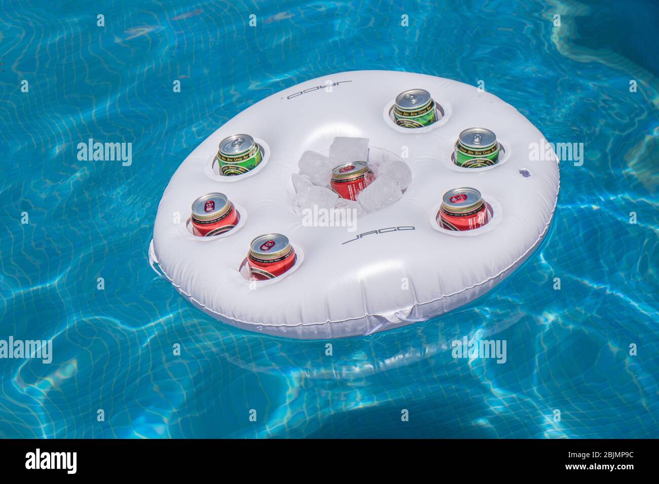 Swimming pool with cans of beer in a floating drinks cooler Stock Photo
