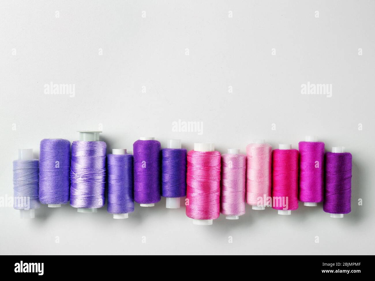 Violet and pink threads of different shades on white background Stock ...