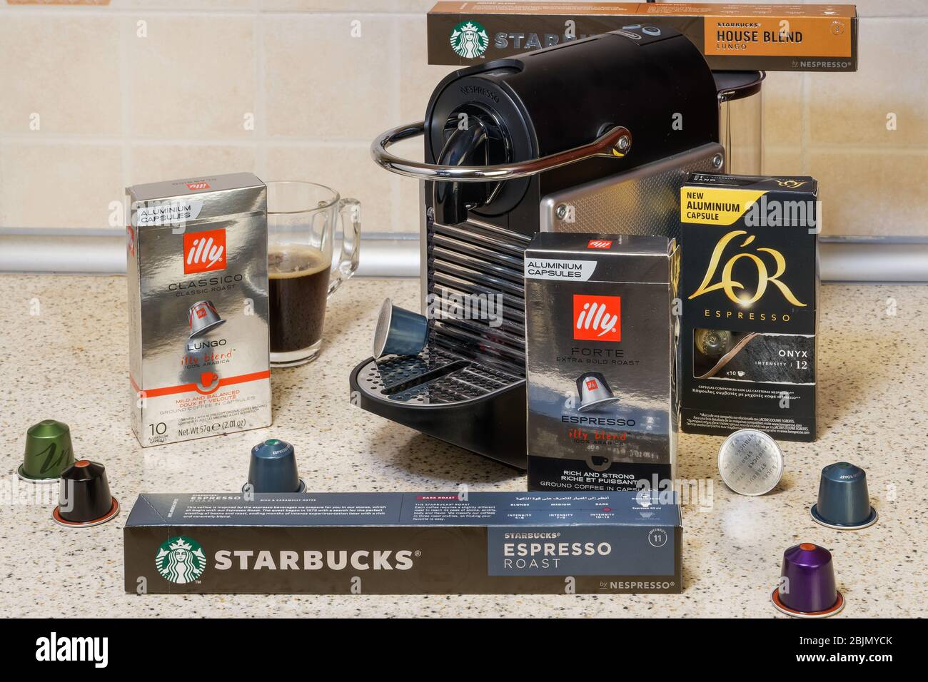 Automatic Nespresso machine used to create aluminum capsules espresso.  Starbucks, Illy & L'OR metal pods around coffeemaker, for making dripping  coffe Stock Photo - Alamy