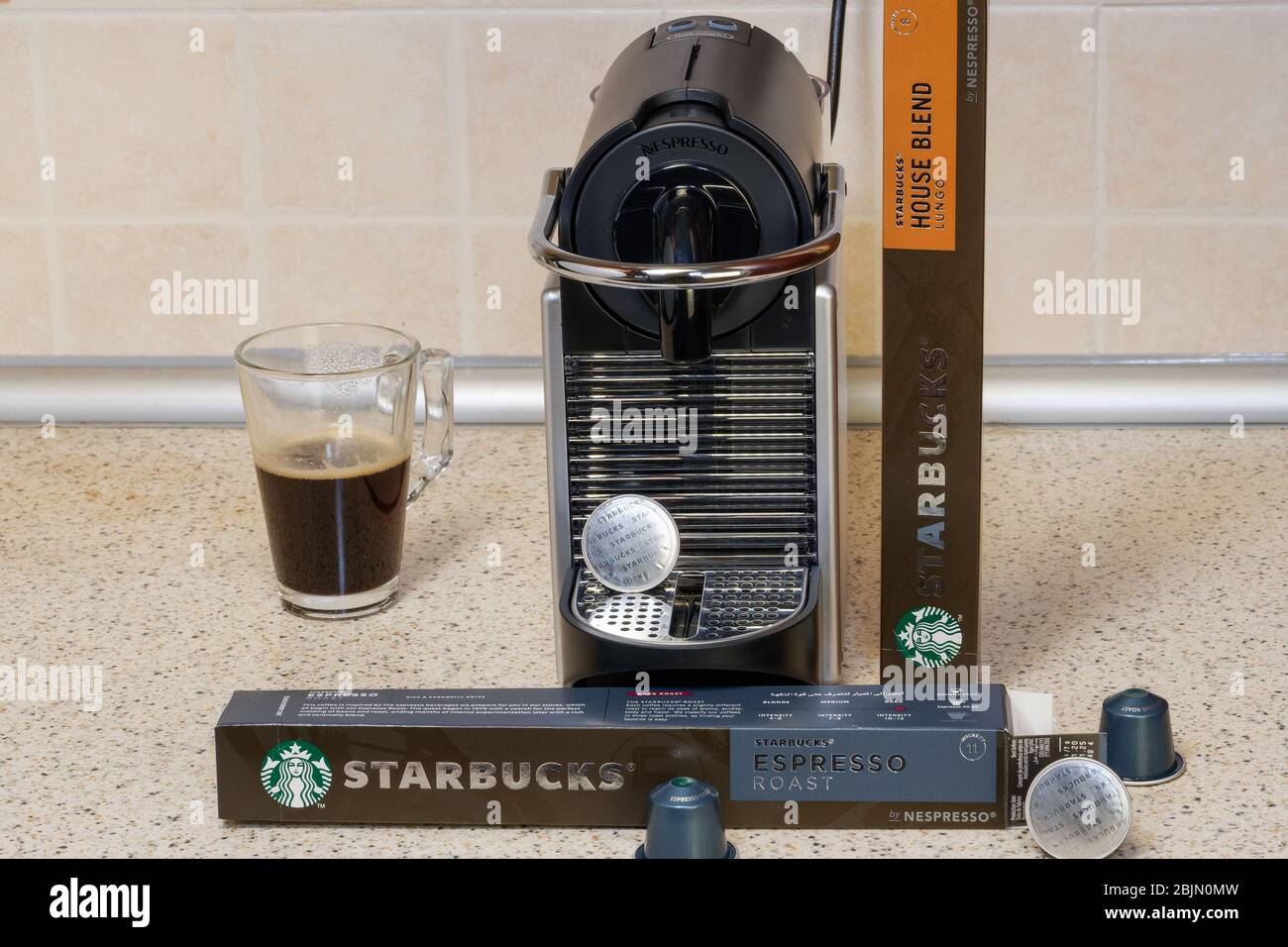 Automatic Nespresso machine used to create espresso with aluminum capsules.  Starbucks metal pods around coffeemaker for making hot dripping coffee  Stock Photo - Alamy