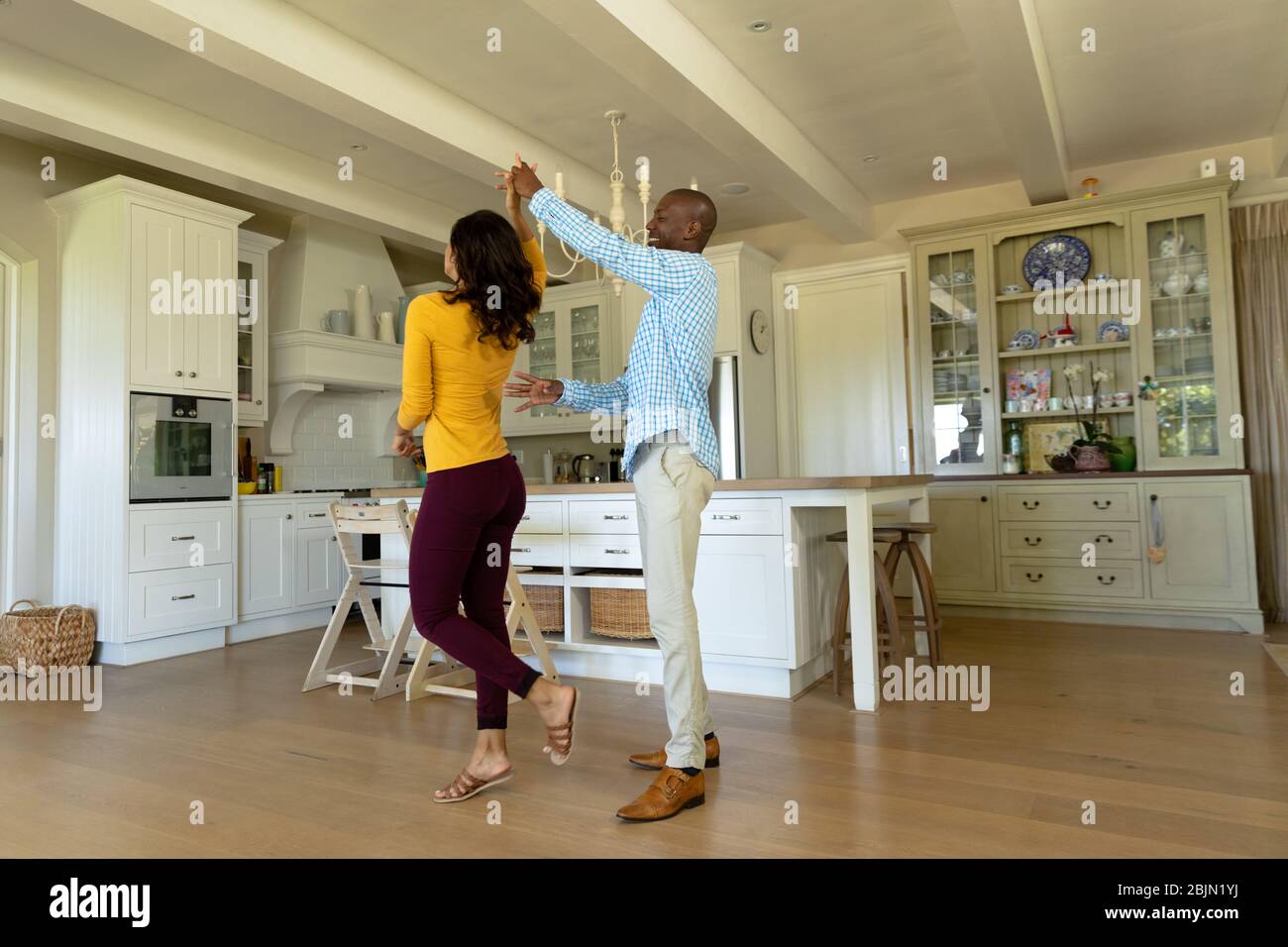 Happy couple dancing in their kitchen Stock Photo