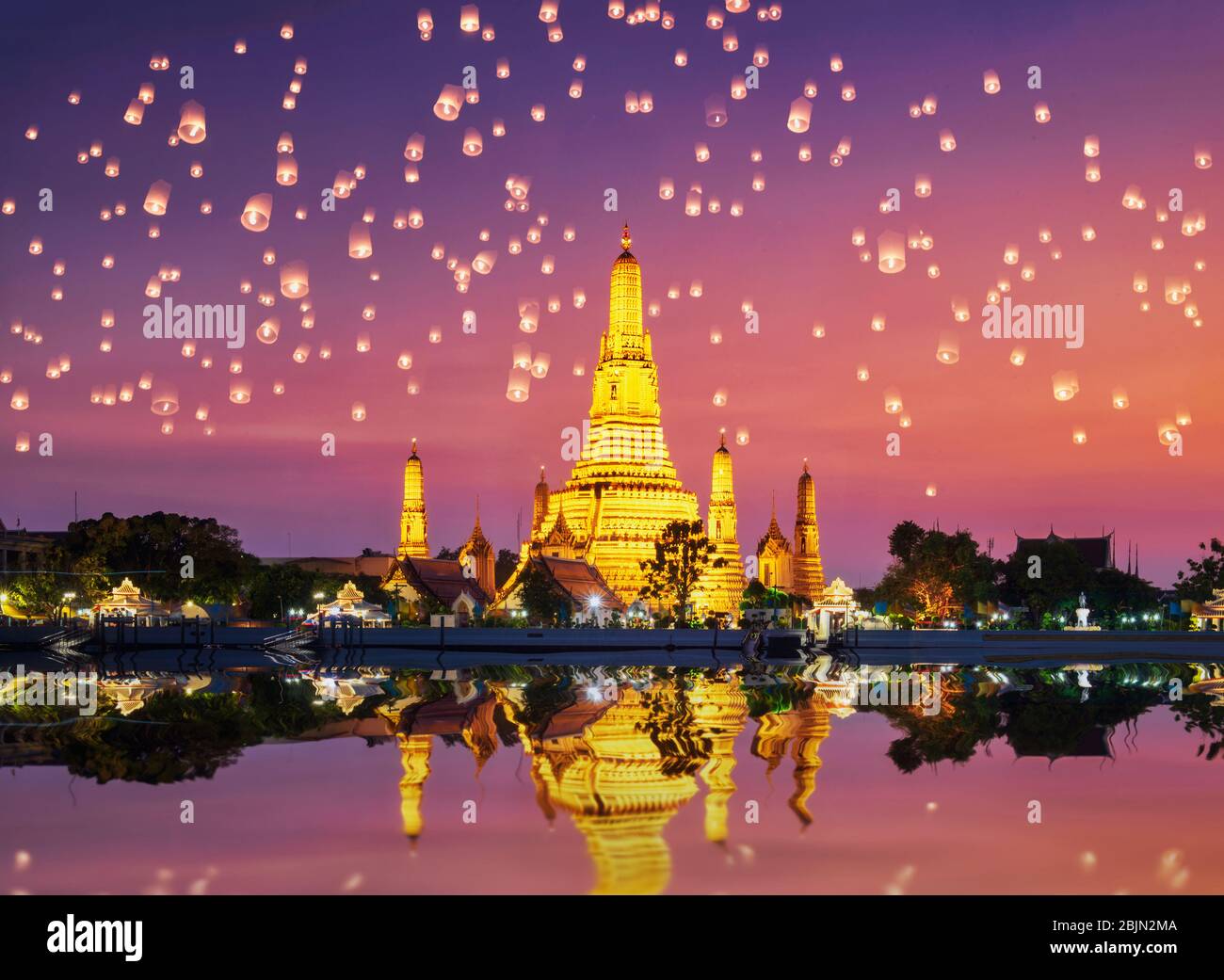 Wat Arun Temple Complex with Chinese lanterns in the sky at sunset, Bangkok, Thailand Stock Photo