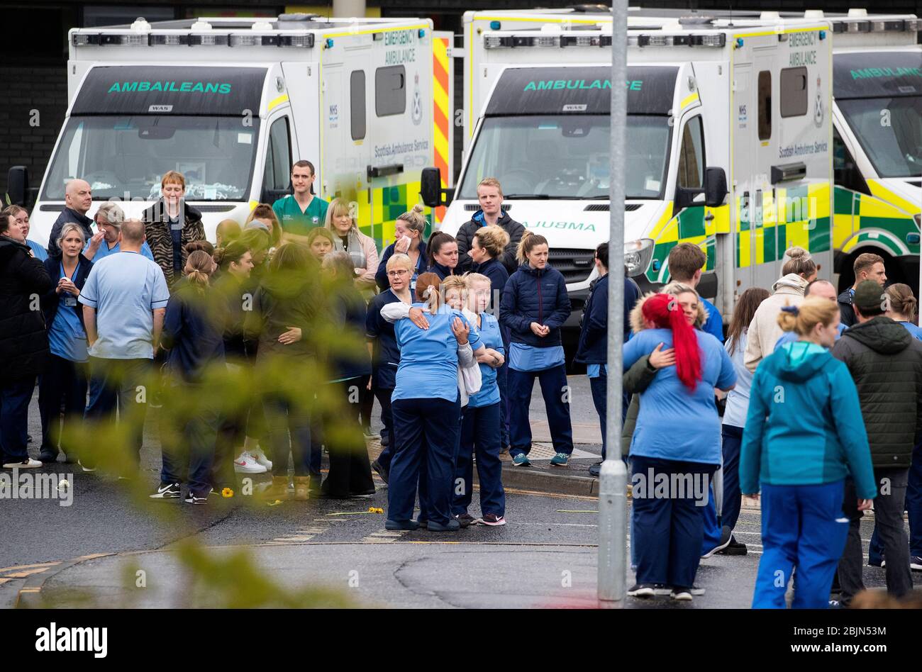 NHS staff comfort and console each other after the funeral cortege of NHS worker Jane Murphy passed the Accident and Emergency department at the Edinburgh Royal Infirmary, Edinburgh. Stock Photo