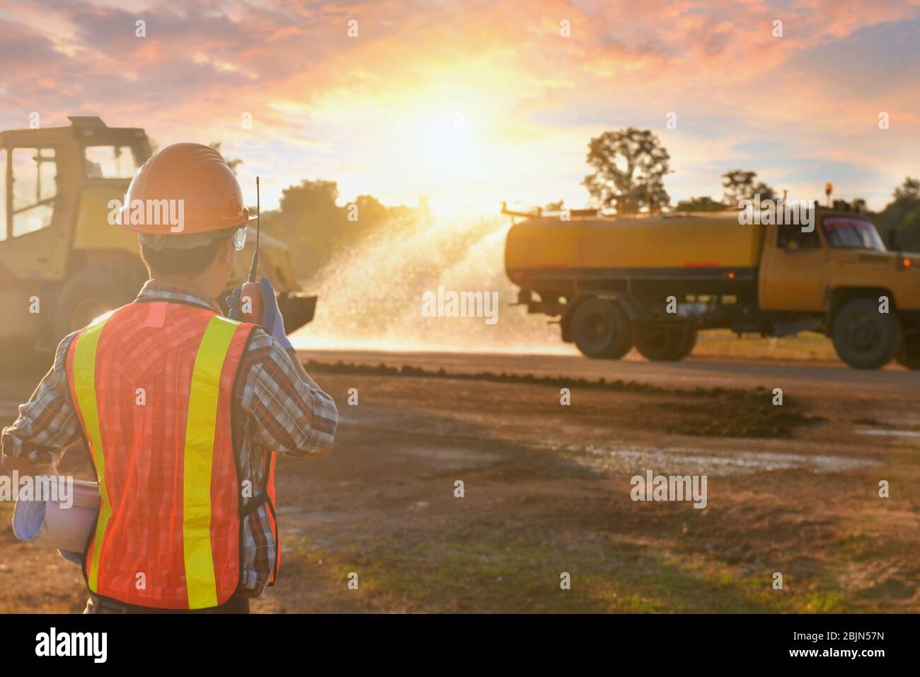 Engineer working on a construction site at sunset, Thailand Stock Photo