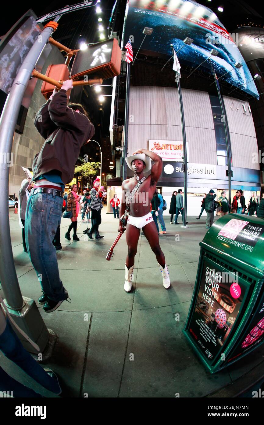 Naked Cowboy showing muscles on Times Square, New York Stock Photo