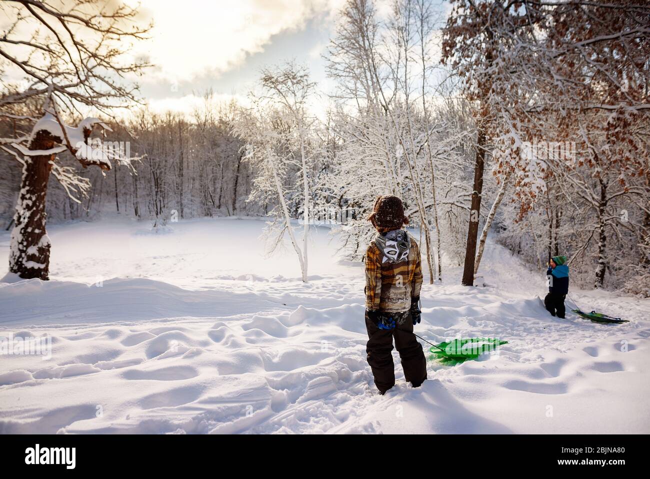 Two boys pulling a sledge through the snow, USA Stock Photo