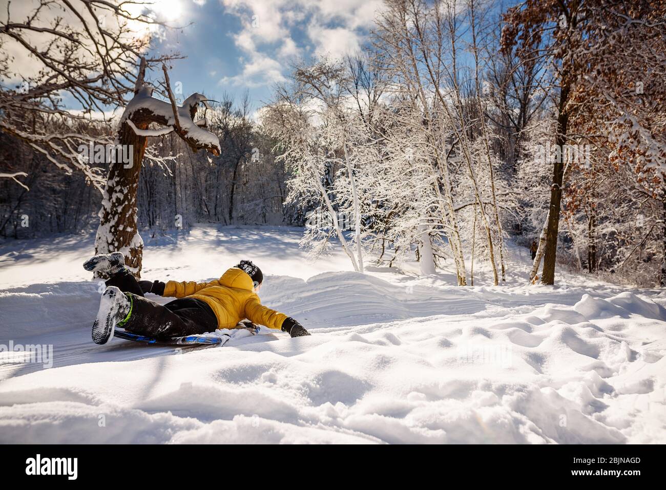 Boy sledding down a hill in the snow, USA Stock Photo