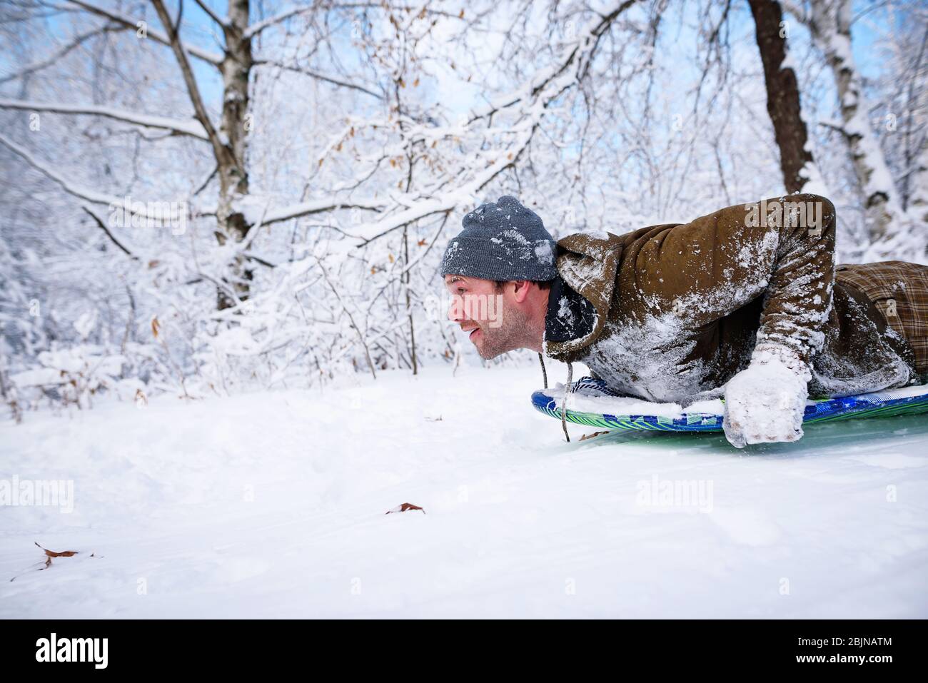 Man sledding down a hill in the snow, USA Stock Photo