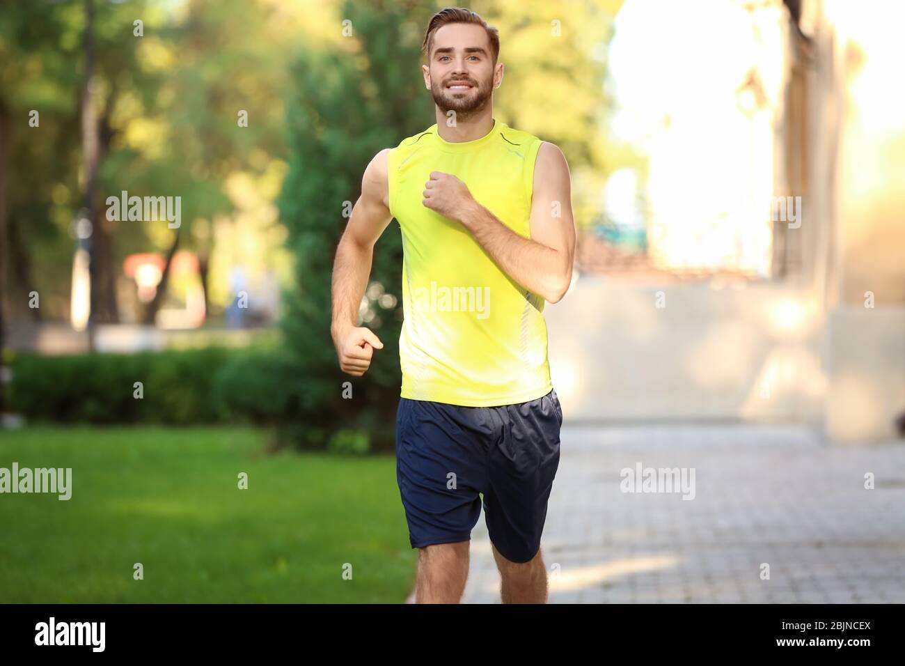 Sporty young man running outdoors Stock Photo - Alamy