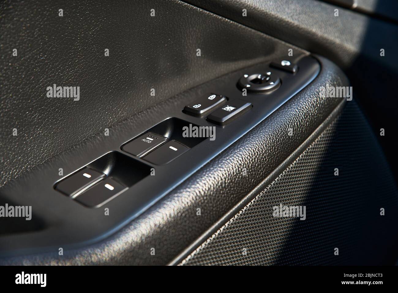 closeup of a door control panel in a new car. Arm rest with window
