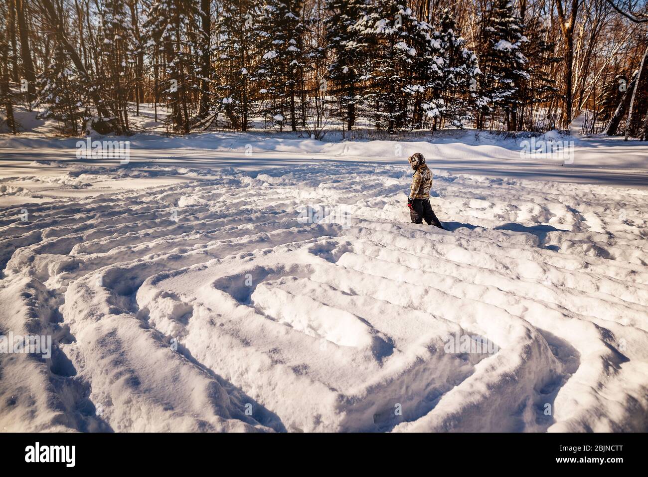 Boy walking through a snow maze, USA Stock Photo