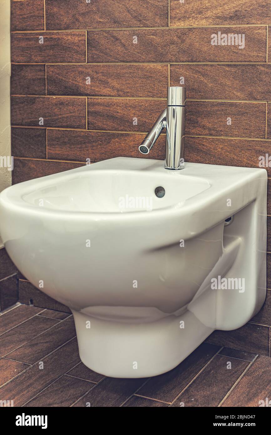 White built in bidet in modern bathroom with brown tiled wall Stock ...