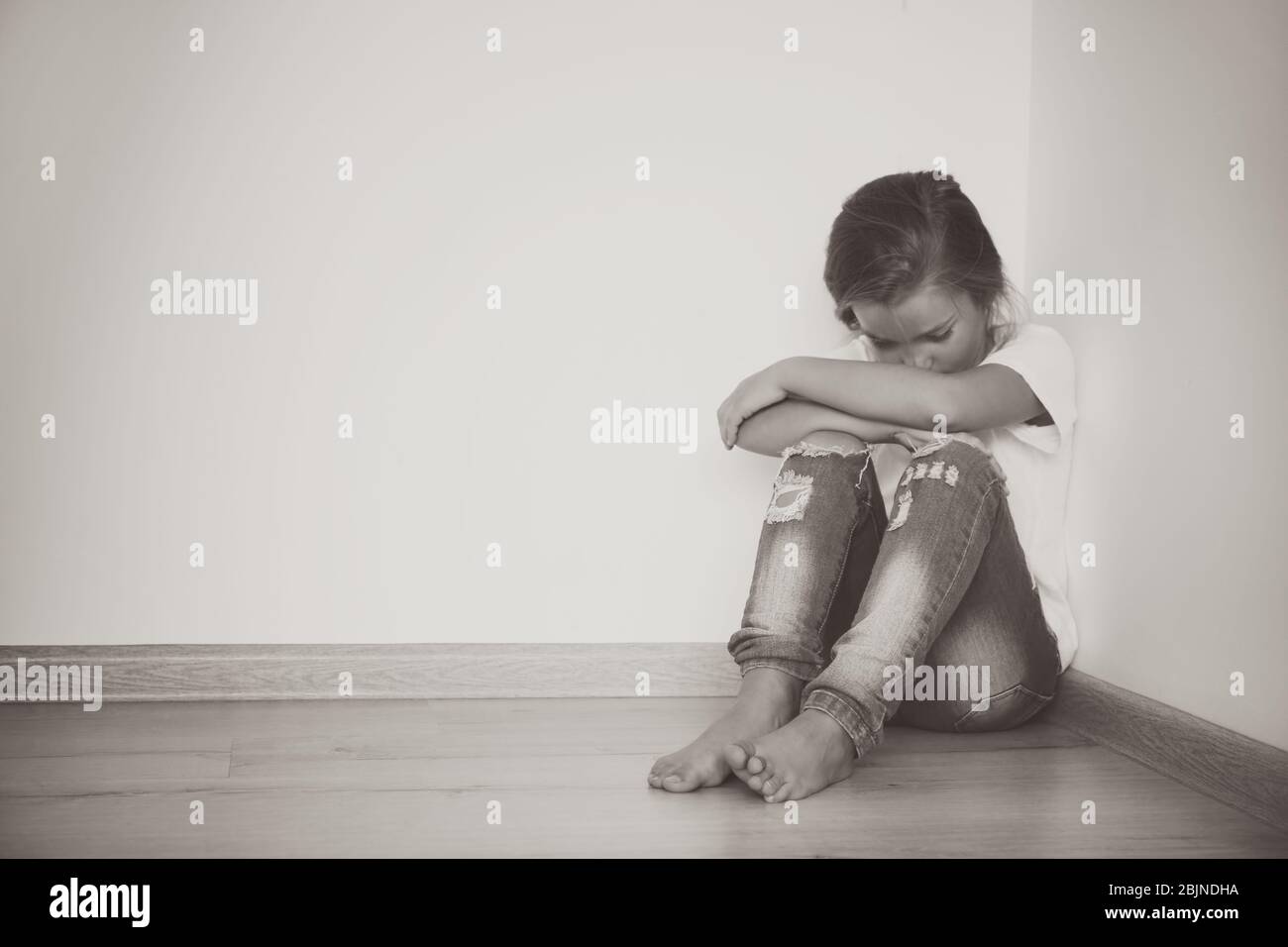 Little sad girl sitting on floor at home Stock Photo - Alamy
