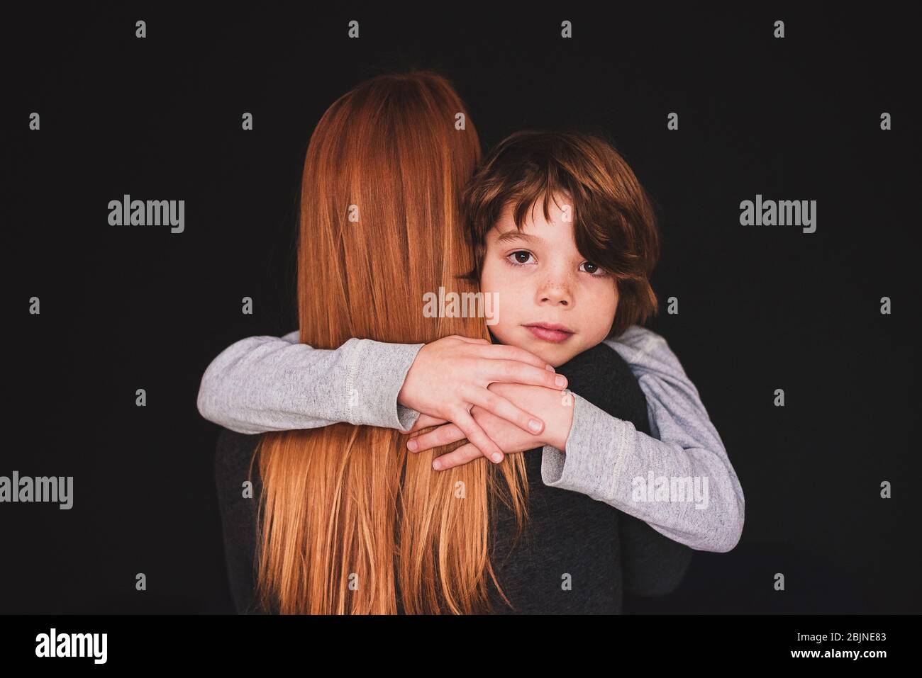Rear view of a woman hugging her son Stock Photo