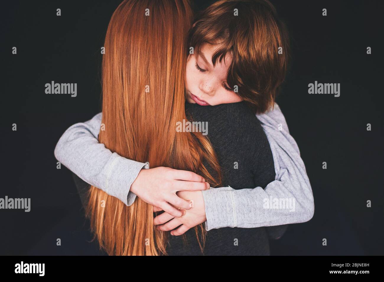 Rear view of a woman hugging her son Stock Photo