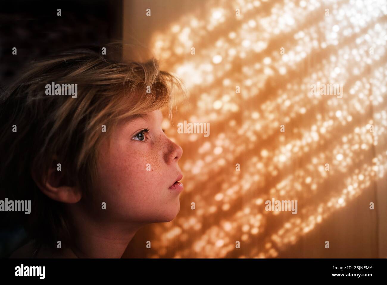 Portrait of a boy standing by a wall Stock Photo