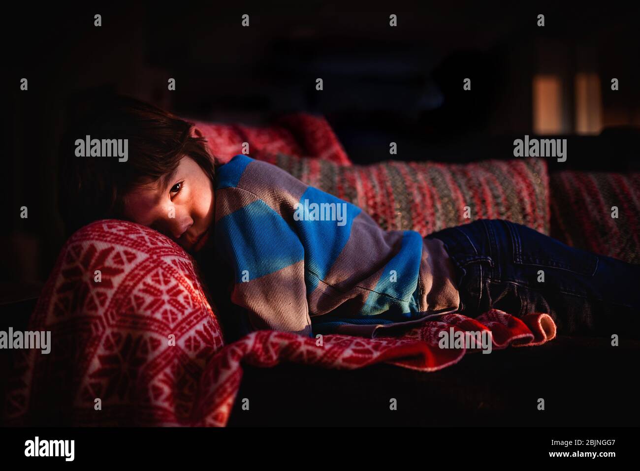 Boy lying on a sofa relaxing Stock Photo