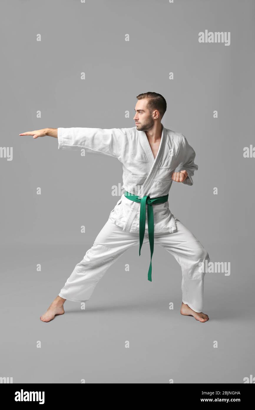 Young man practicing karate on light background Stock Photo - Alamy