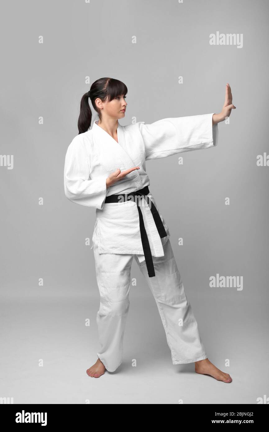 Young woman practicing karate on light background Stock Photo
