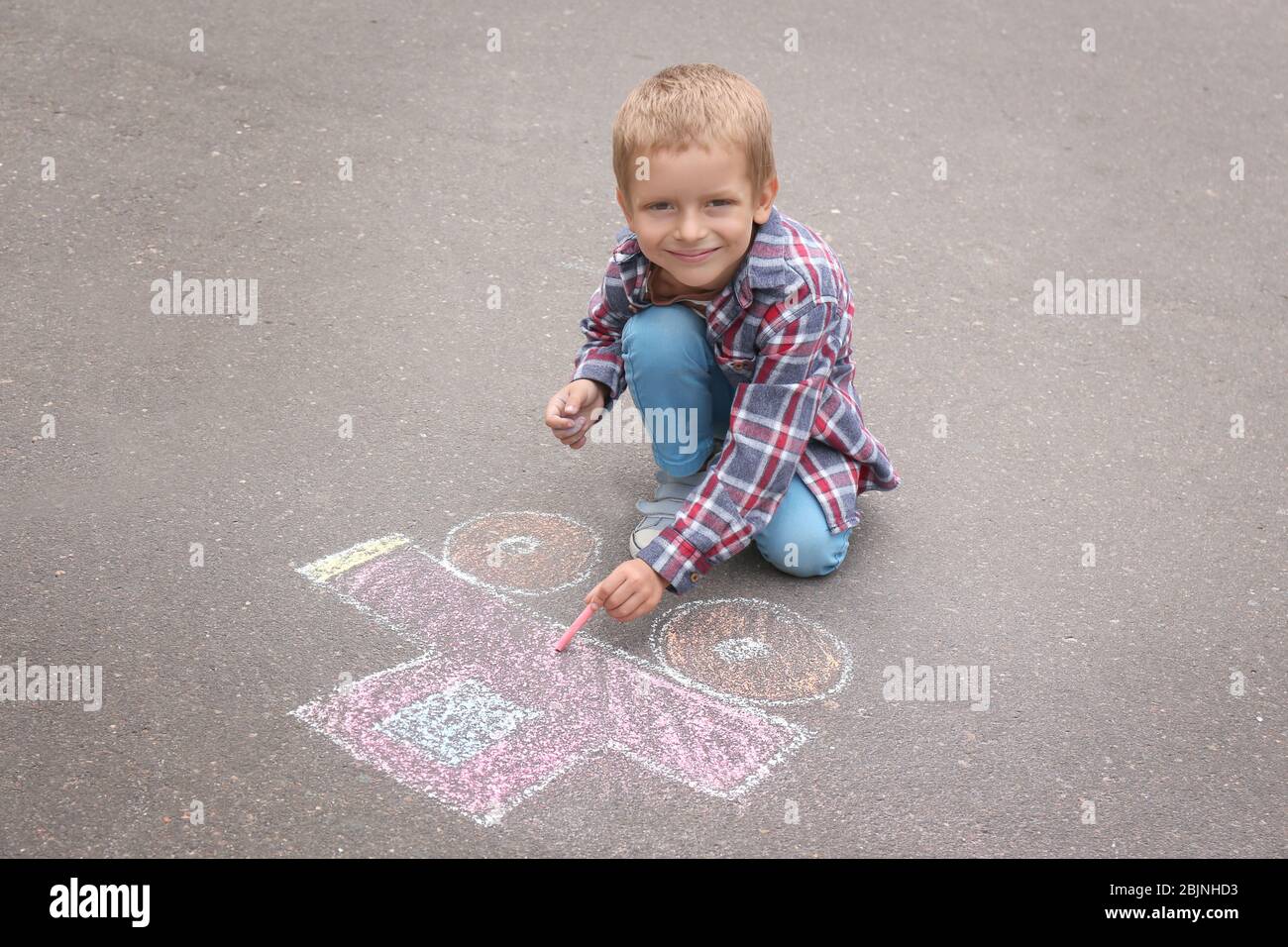 Little boy drawing car with chalk on asphalt Stock Photo - Alamy