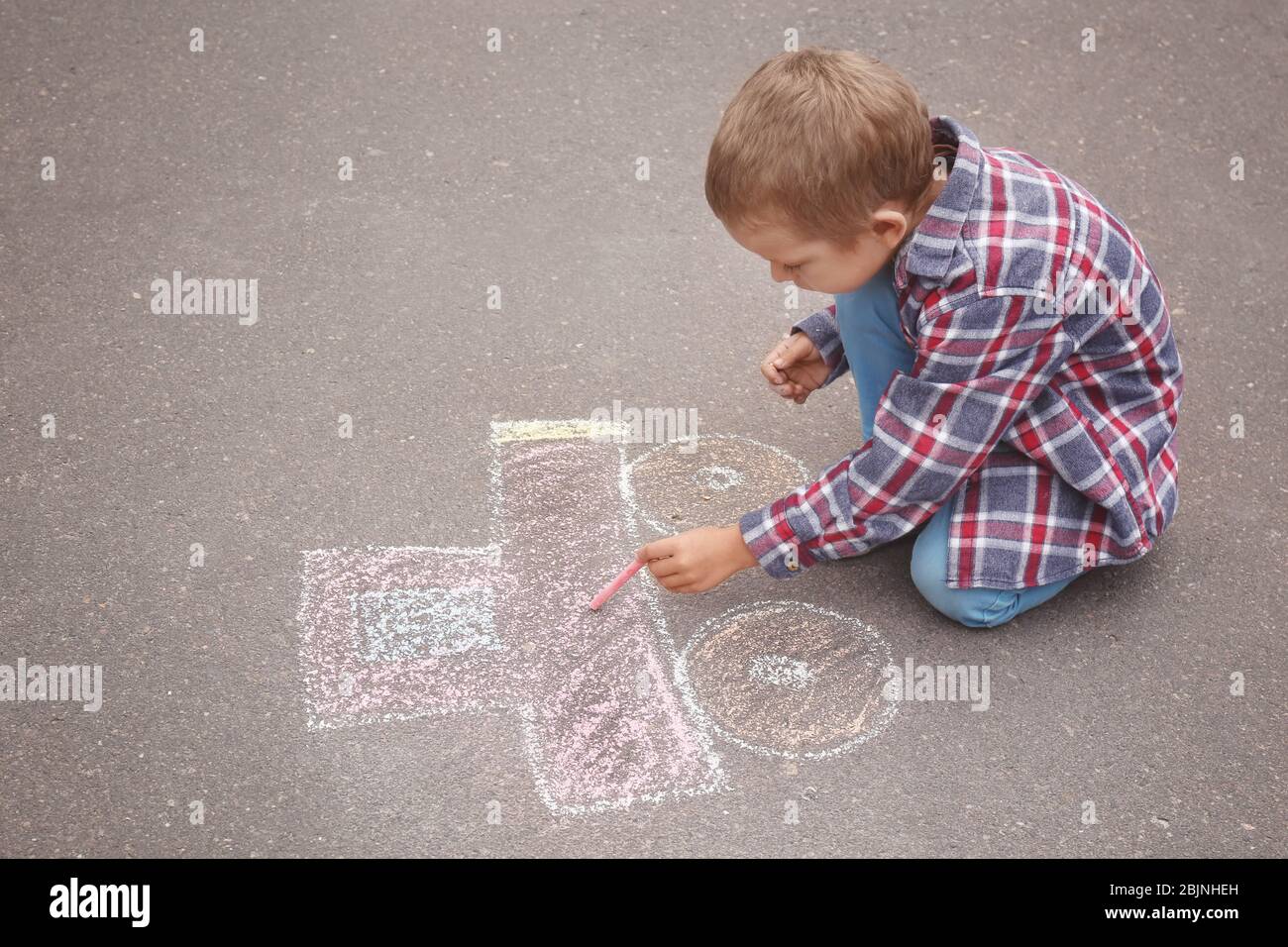 Little boy drawing car with chalk on asphalt Stock Photo - Alamy