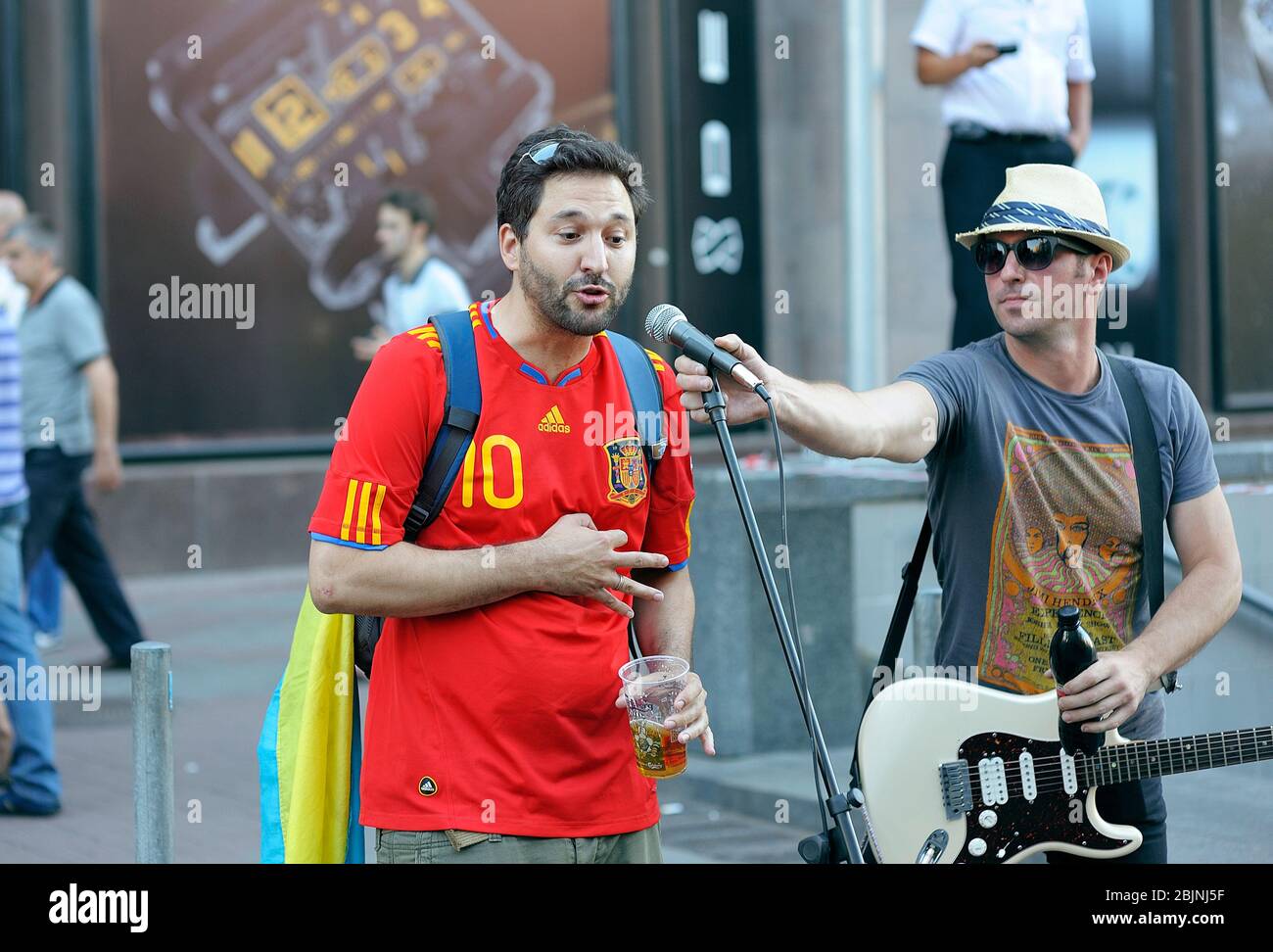 Drunk soccer Spanish fan wearing red Tshirt singing into the