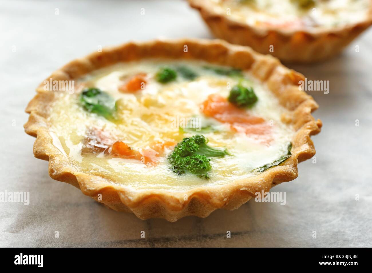 Tasty salmon tartlet on parchment, closeup Stock Photo Alamy