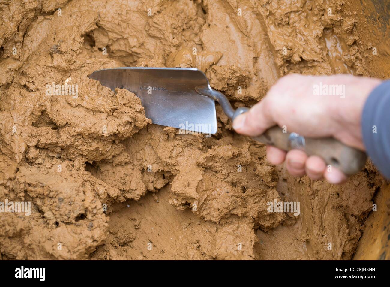 wild bee nesting aid made with mud, merging of clay with water and sand, series picture 1/5, Germany Stock Photo