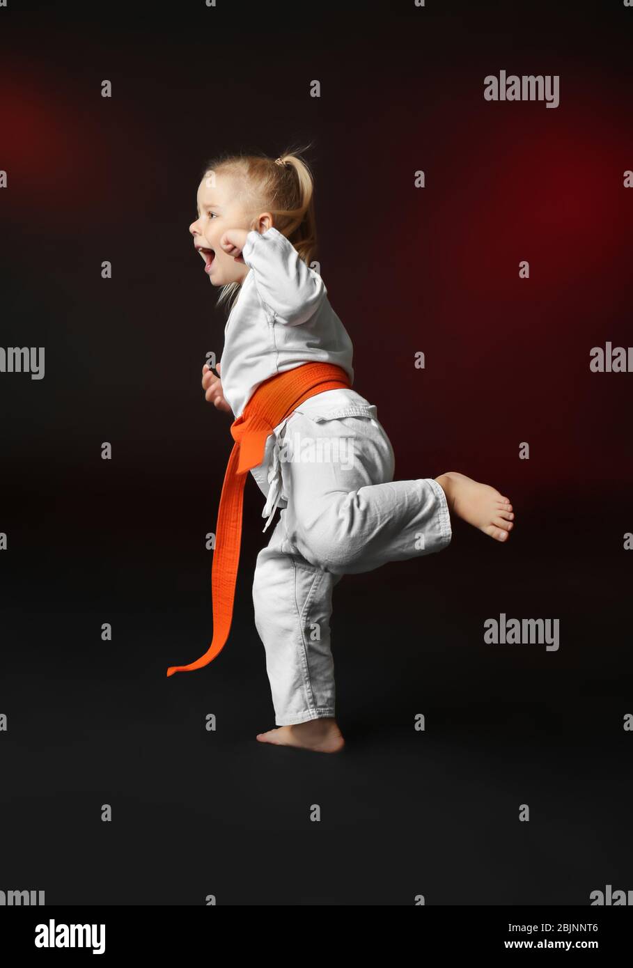 Little girl practicing karate on dark background Stock Photo Alamy