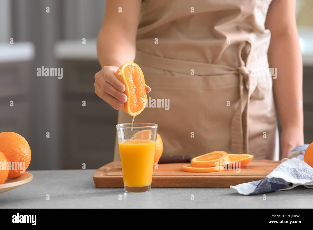 Female hand squeezing orange juice from fresh oranges with a juicer in the  home kitchen, ?lose up Stock Photo - Alamy