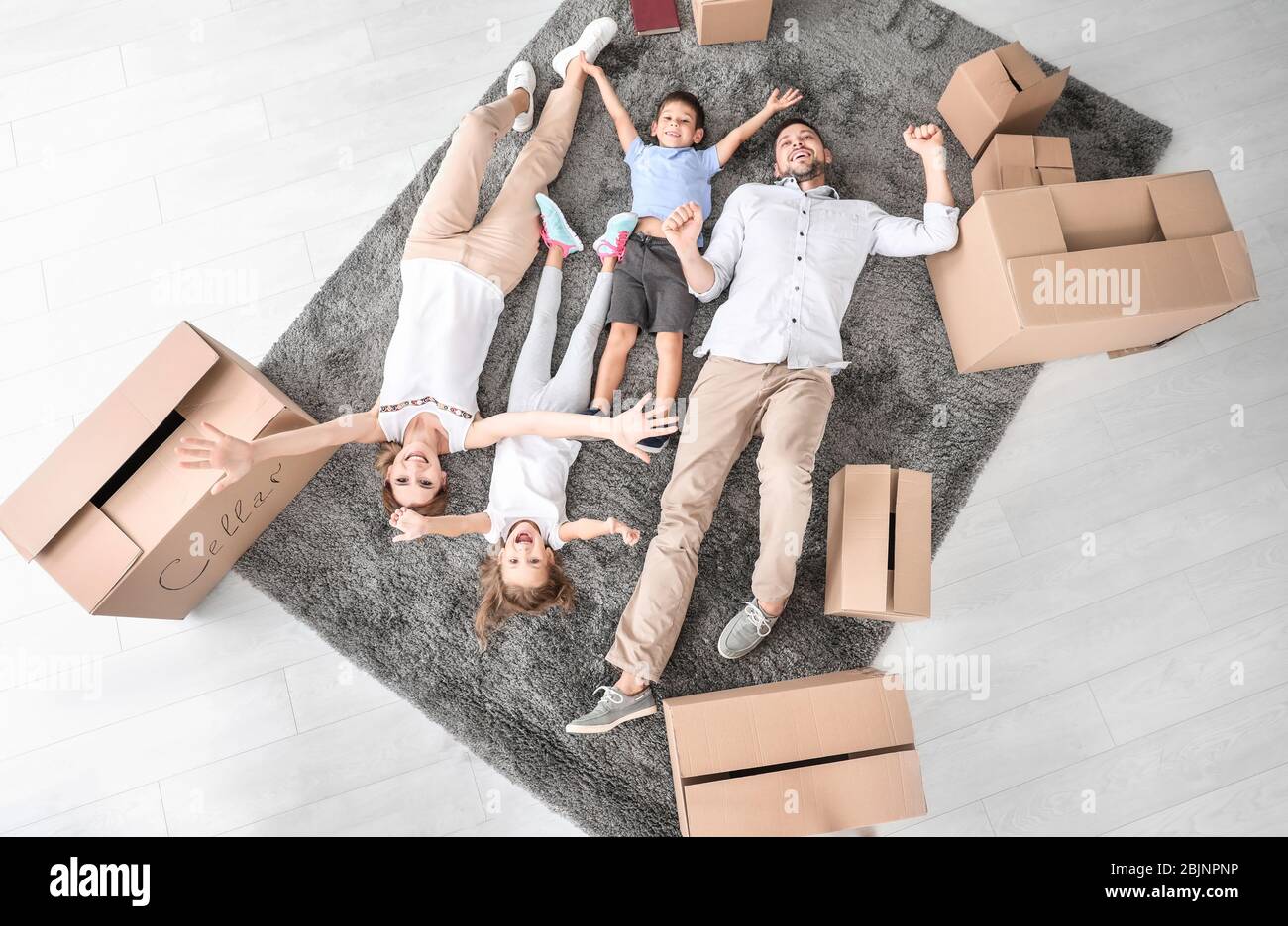 Tired family lying on floor in new flat. Move house concept Stock Photo ...